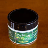 Picture of our Ointment in a 1 ounce jar with black lid